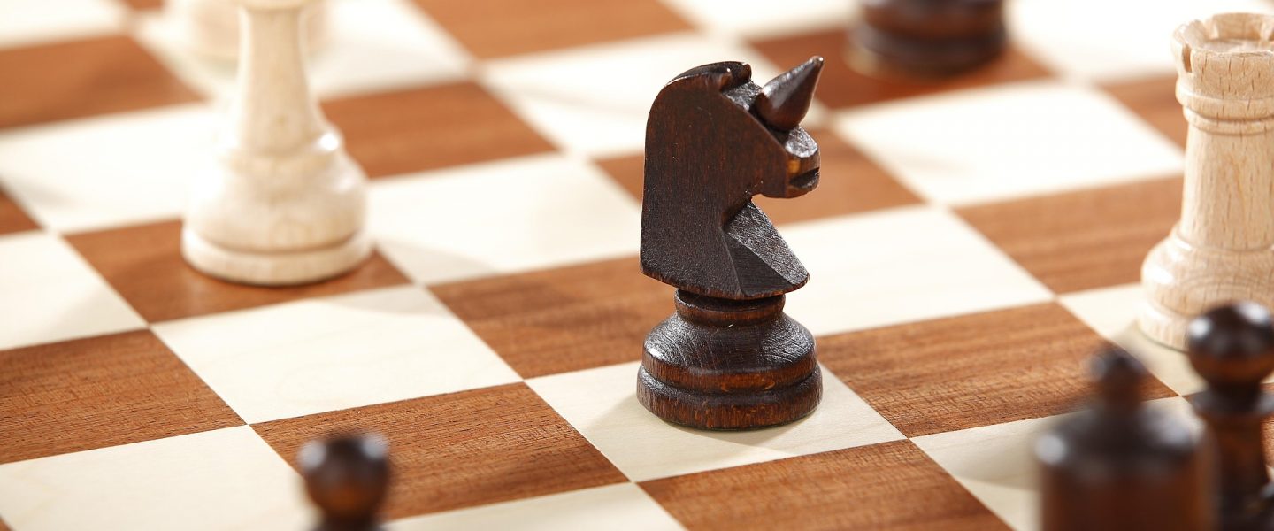 Schachbrett mit einem Einhorn als schwarzem Springer